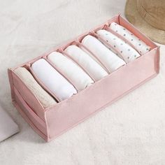 a pink drawer with six folded pillows in it