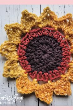 a crocheted sunflower is shown on a white wooden surface with text overlay