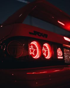 the tail light of a red sports car with stars and circles on it's hood