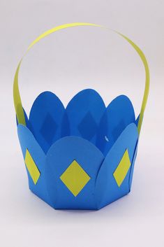 a blue paper crown with yellow tape around the edges and two hearts on each side