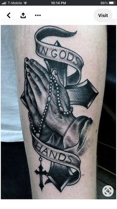 a black and white tattoo with an image of two hands holding a cross, in god's hands