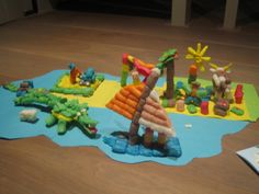 a bunch of toys that are laying on the floor in front of some water and sand