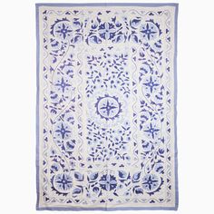 a blue and white rug with an intricate design on the bottom, in front of a white background