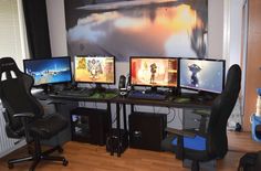 three computer monitors sitting on top of a desk next to a keyboard and monitor screen