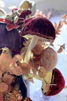 an assortment of decorative items on display in a store window, including mushrooms and leaves