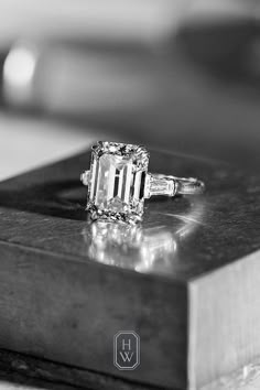 an emerald - cut diamond ring sits on a table