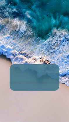 an aerial view of the ocean with waves coming in from the sand and blue water