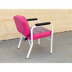 a pink and white chair sitting in front of a wall