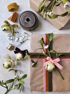 two wrapped presents with ribbons and bows on them next to some other wrapping supplies,