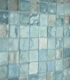 a close up view of some blue glass tiles on the wall in a bathroom area