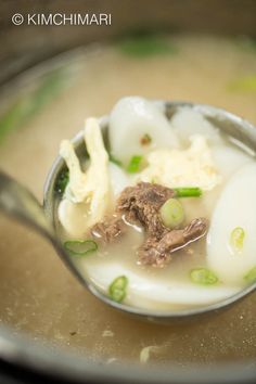 a spoon full of soup with meat and vegetables