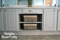 a bathroom with white cabinets and towels on the bottom shelf in front of the sink