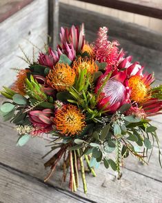 a bouquet of flowers sitting on top of a wooden table