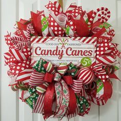 a candy cane wreath hanging on the front door for someone's christmas decorating