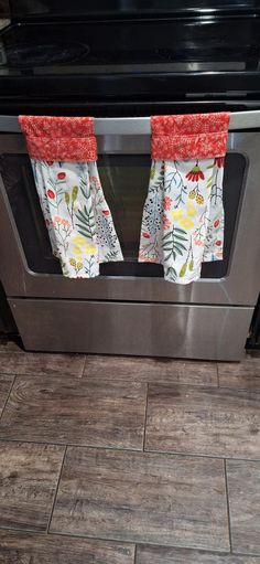 two kitchen towels hanging on the oven door