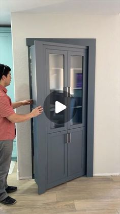 a man is opening the door to a cabinet