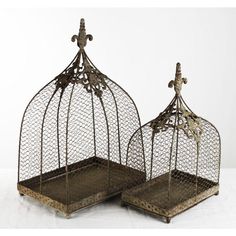 two metal birdcages with crosses on the top, one is open and the other has