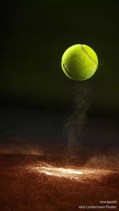 a tennis ball is flying into the air with dust coming out of it's bottom