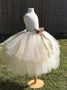 "This listing includes an ivory and champagne/beige tutu with a gold glitter bow. This listing if for waist sizes up to 34 1/2\" can be made larger if interested contact me for a special listing. Other colors also available. The ivory and champagne/beige tutu pictured is the 19-24\" length range with a longest layer of 20\" and top layer of 17\". Tutu can be all one length or the dual lengths. **please just note the length you would like or lengths you would like upon checkout Thank you for shop Cream Tulle Tutu Dress For Wedding, Fitted Cream Tutu Dress With Tulle Skirt, Gold Ruffled Tutu Dress For Wedding, Princess Style Cream Tutu Dress With Ruffles, Fitted Gold Tulle Tutu Dress, Cute Cream Tutu Dress For Dress-up, Gold Tulle Tutu Dress With Ruffles, Gold Fitted Tutu Dress For Dress-up, Gold Sequined Tutu Dress For Dress-up