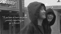 black and white photograph of two people standing in front of a pub with the caption if you have at least one person, seriously supporting you, you'll be messed