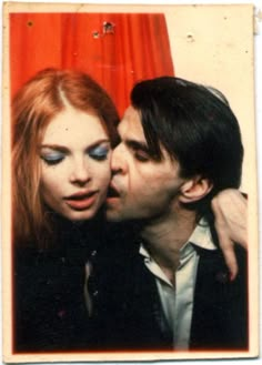 a man kissing a woman on the cheek