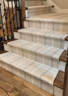 the stairs are lined with carpet and wooden handrails