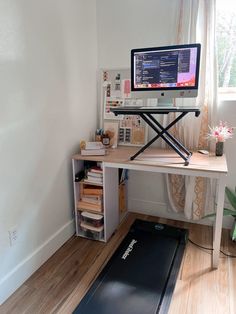 a computer desk with a treadmill on top of it in front of a window