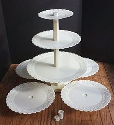 three tiered cake stand with white plates on it