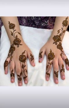 a woman's hands with hennap and flowers painted on her hand,