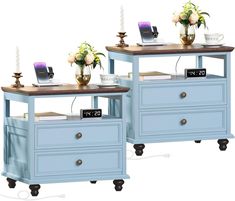 two blue nightstands with flowers on them and an alarm clock next to each other