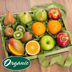 an open box filled with lots of different types of fruit on top of a wooden table