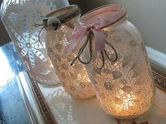 two mason jars with lace doily on them