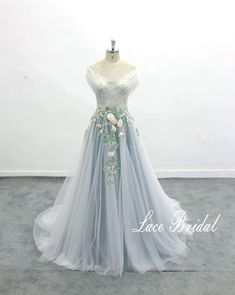 a dress on a mannequin with flowers in the middle and green trimmings