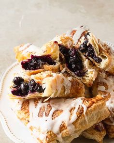 a white plate topped with pastries covered in blueberries