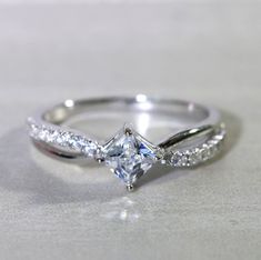 a white gold ring with a princess cut diamond