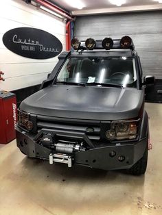 an suv is parked in a garage with lights on it's roof and front bumper