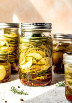 several jars filled with pickles and spices