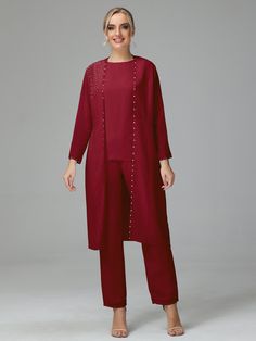 a woman wearing a red pant suit with beading on the bottom and sleeves