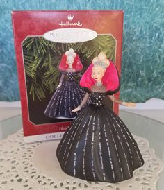 a christmas ornament with two women in dresses on top of a doily