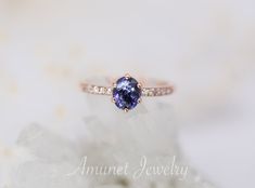 a close up of a ring with a blue stone in the center and diamonds around it