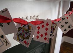 some cards are hanging on a clothes line with red ribbon and bow around the strings