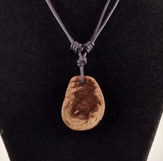 The Petrified Wood pendant is approximately 1.3 inches in length on natural black polished round leather. The necklace is adjustable from 15 inches to 30 inches by sliding the knots. The pendant is polished on both sides. This pendant was cut from a small limb collected in Wyoming. The outside edge of the pendant is the natural surface of the petrified wood. Petrified wood is fossilized remains of terrestrial vegetation. It is the result of a tree or tree-like plants having completely transition Adjustable Round Pendant Waxed Cord Jewelry, Types Of Fossils, Stone Molds, Plant Cell, Black Polish, Round Leather, Wood Pendant, Organic Matter, Petrified Wood