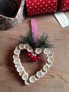 a heart shaped ornament with buttons and pine needles in the shape of a heart