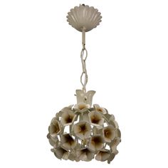 a white chandelier with flowers hanging from it's center point, on a chain