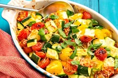 a casserole dish with tomatoes, zucchini and other vegetables