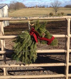 a christmas wreath hanging on a fence