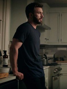 a man standing in a kitchen next to a stove top oven