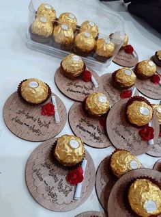 there are many chocolates on the table with gold foiled decorations and red roses