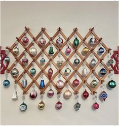 a wooden rack with ornaments hanging from it's sides and on the wall behind it