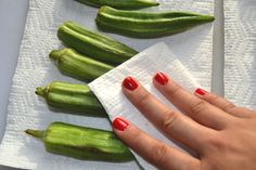 a woman's hand on napkin next to green beans